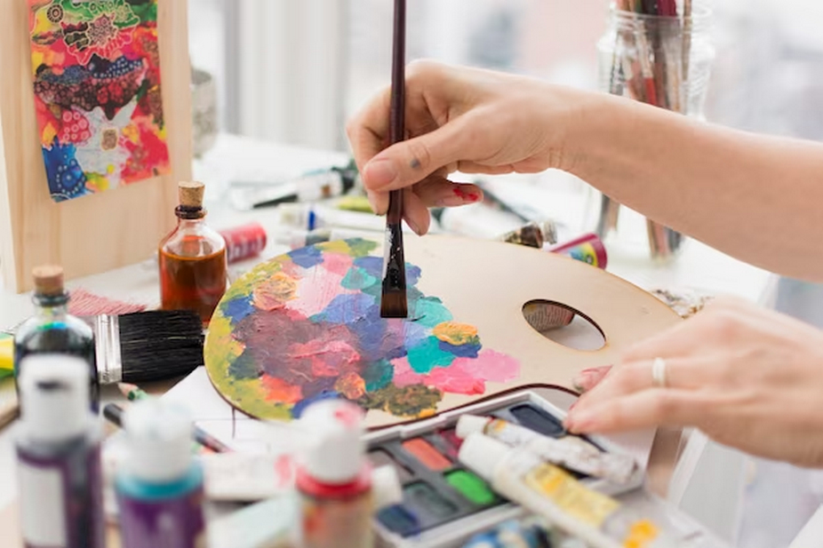 Artist mixing paint on a painting palette.