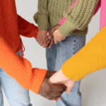 Group of friends forming a circle while holding hands.