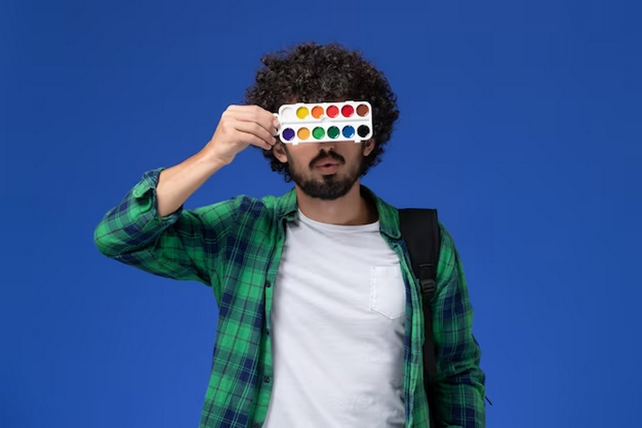 Man covering his eyes with watercolor palette