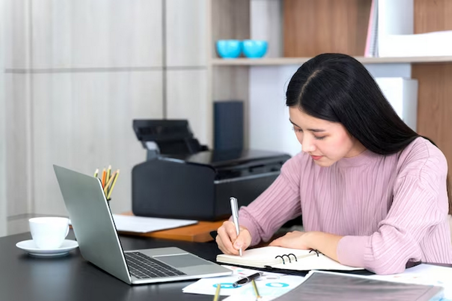 Note-taking in front of a computer.