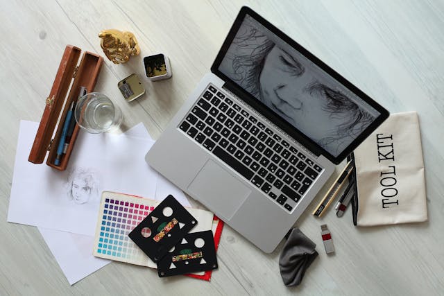 A table with a laptop, pencils, and various supplies, all arranged neatly. Ideal for Graphic Design