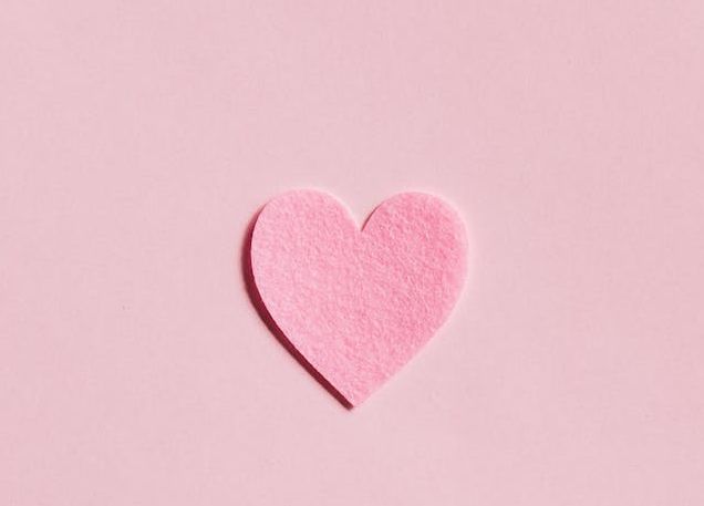 Pink heart on pink background symbolizing romance and love